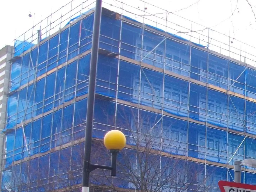 Netted scaffold wrapping the corner of a multi-storey block in Basingstoke