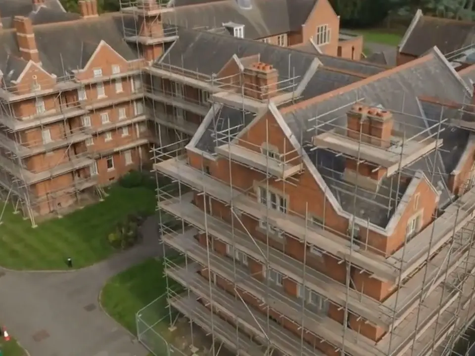 Aerial view of scaffold platforms around the chimney stacks of an Oxford college building
