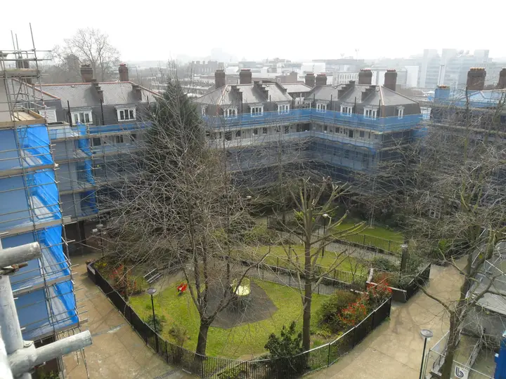 Netted scaffolding around the courtyard of a Kings Cross estate, seen from the top of the scaffold