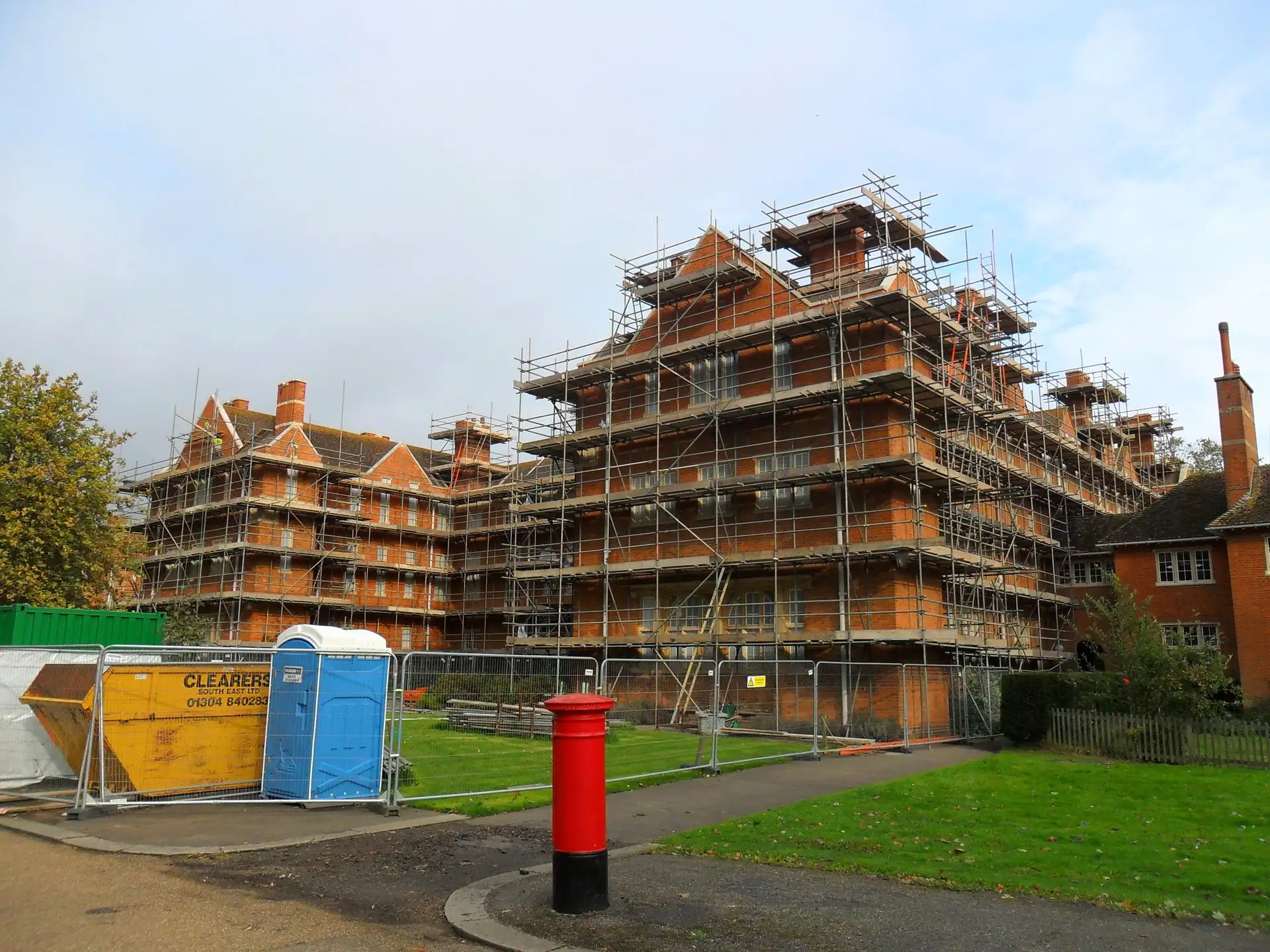 Independent scaffold on red-brick Oxford college buildings beside a lawn